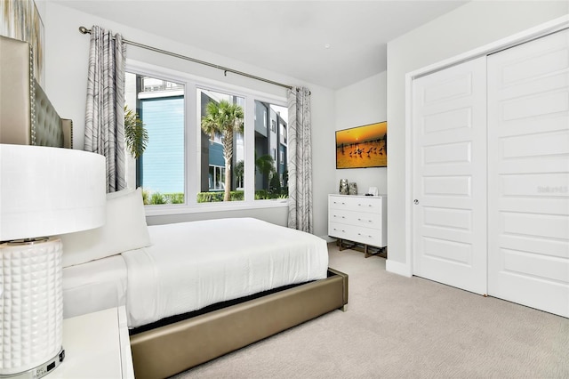 bedroom featuring light carpet and a closet