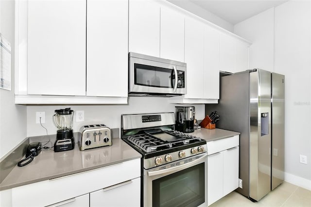 kitchen with white cabinetry, appliances with stainless steel finishes, and light tile patterned floors