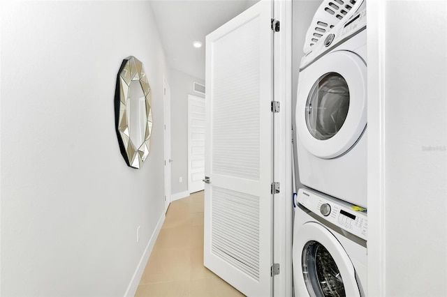 clothes washing area featuring stacked washer and clothes dryer