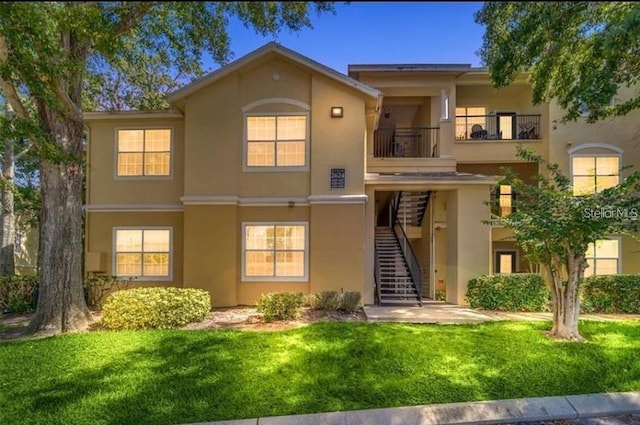 view of front of home with a front yard and a balcony