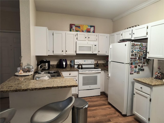 kitchen featuring sink, white cabinetry, dark stone countertops, and white appliances