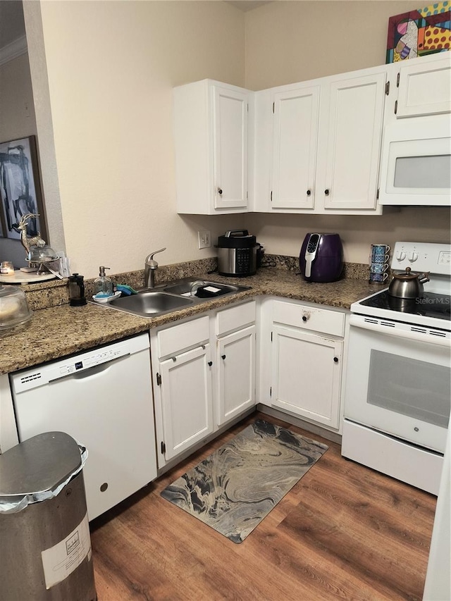 kitchen with dark wood-type flooring, white cabinets, and white appliances