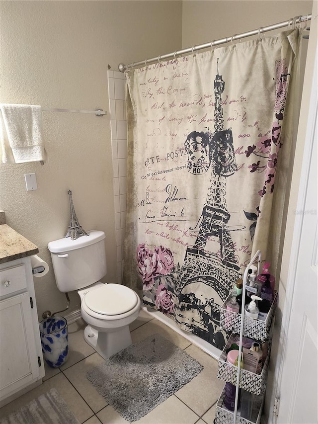 bathroom with toilet, vanity, tile patterned floors, and walk in shower