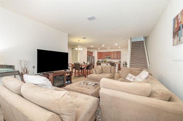 living room featuring an inviting chandelier and a textured ceiling