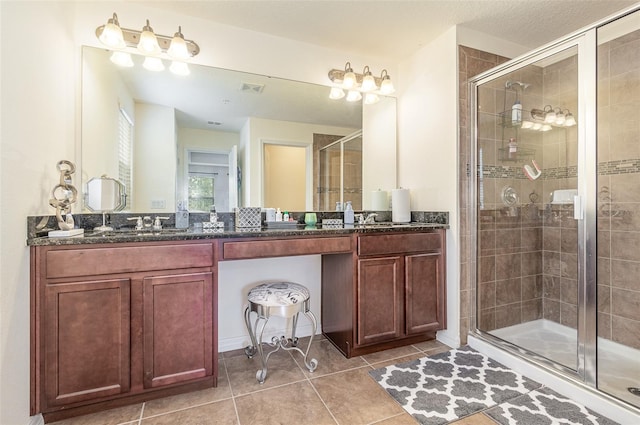 bathroom with tile patterned flooring, vanity, and a shower with door