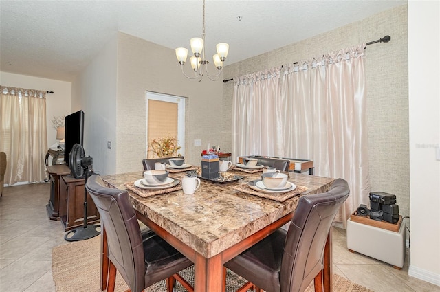 dining space with a textured ceiling, a chandelier, and light tile patterned flooring