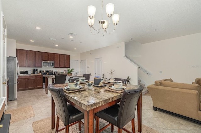 dining room featuring a notable chandelier, a textured ceiling, and light tile patterned flooring