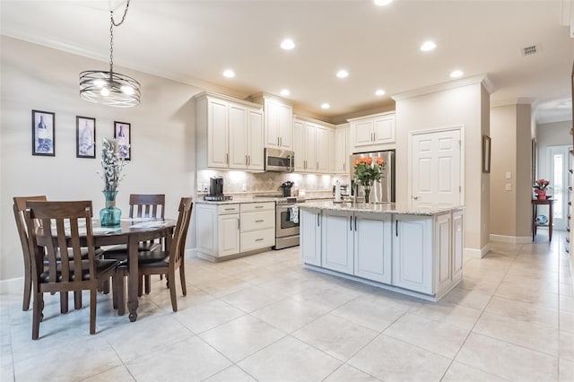 kitchen featuring light stone countertops, pendant lighting, appliances with stainless steel finishes, a kitchen island with sink, and light tile patterned floors