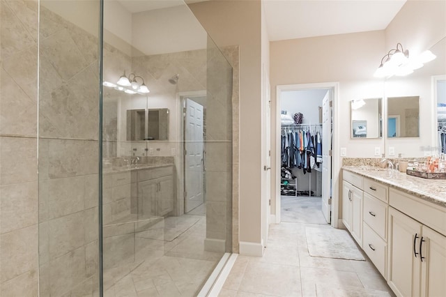 bathroom with vanity, a tile shower, and tile patterned flooring