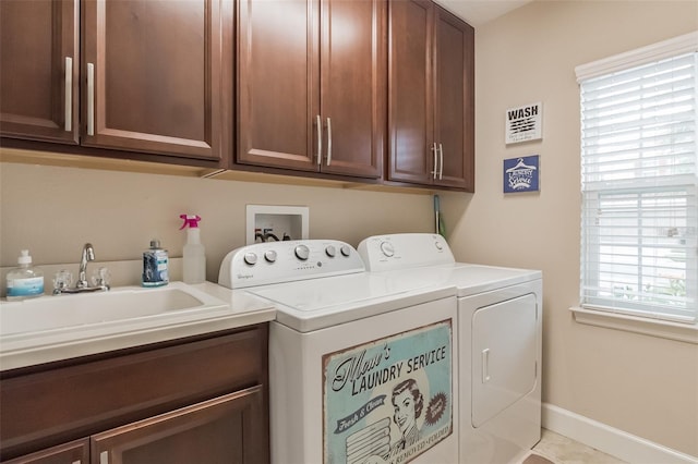 laundry room with washer and dryer, cabinets, sink, and a healthy amount of sunlight