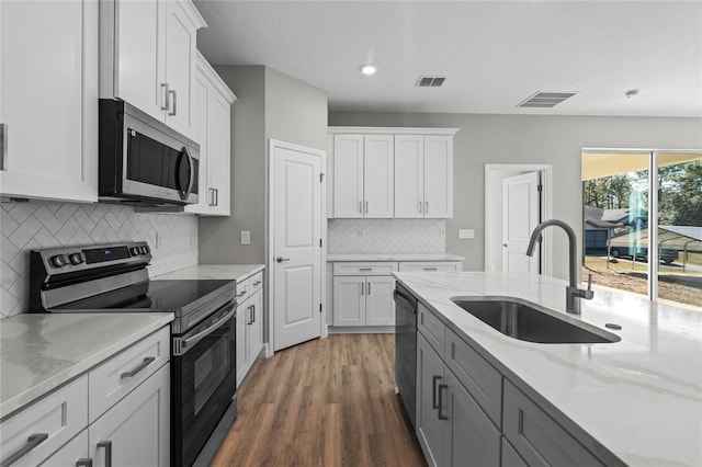 kitchen with sink, white cabinets, tasteful backsplash, and appliances with stainless steel finishes