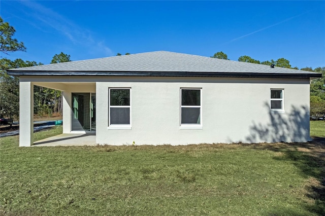 rear view of property featuring a yard and a patio