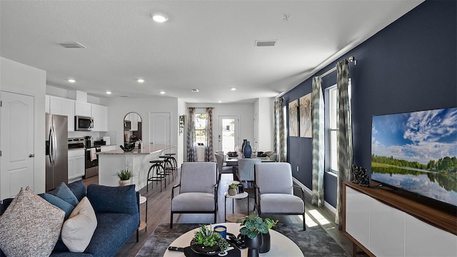 living room with a textured ceiling and dark hardwood / wood-style flooring