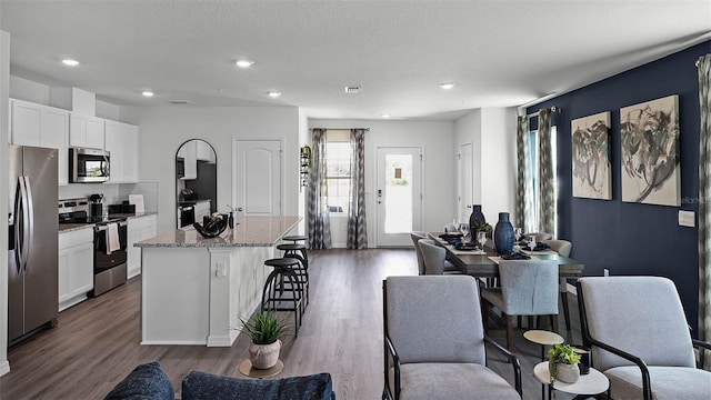 dining room with a textured ceiling and dark wood-type flooring