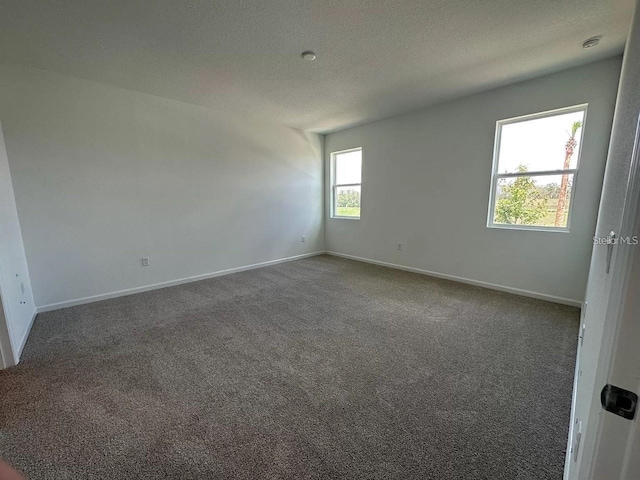 carpeted spare room featuring a textured ceiling