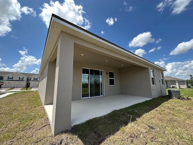 back of house featuring central air condition unit, a yard, and a patio