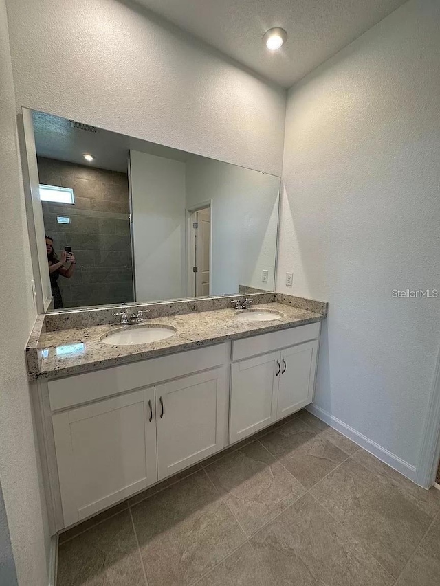 bathroom with vanity and a tile shower