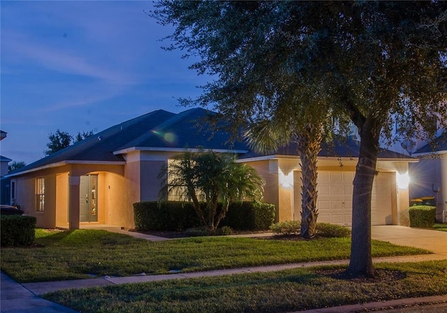 view of front of house featuring a garage and a lawn