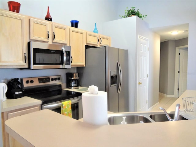 kitchen featuring light brown cabinetry, sink, and stainless steel appliances