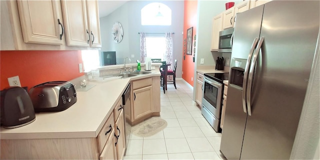 kitchen featuring pendant lighting, appliances with stainless steel finishes, light brown cabinets, sink, and light tile patterned flooring