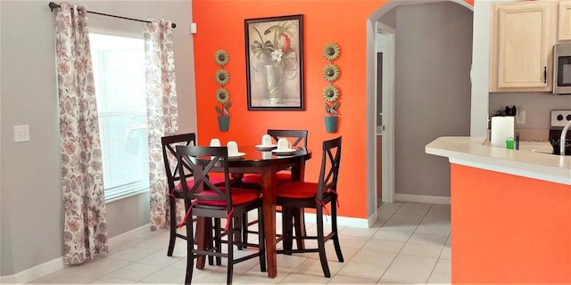 dining area with a wealth of natural light and light tile patterned flooring