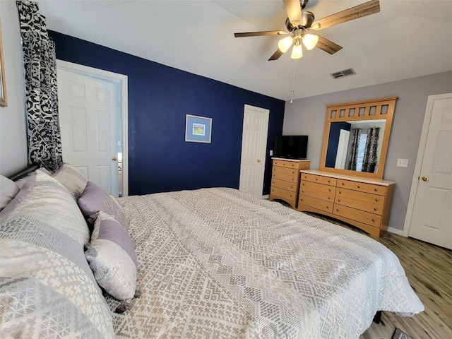 bedroom featuring ceiling fan, a textured ceiling, and hardwood / wood-style floors