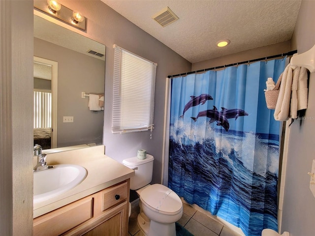 bathroom featuring curtained shower, a textured ceiling, tile patterned flooring, vanity, and toilet