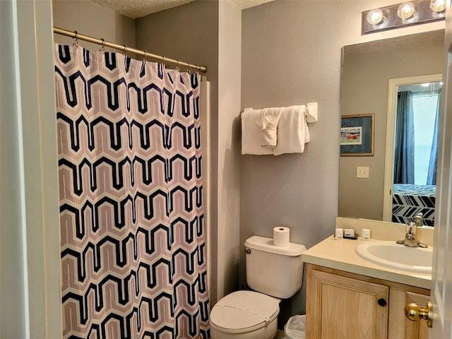 bathroom featuring curtained shower, a textured ceiling, toilet, and vanity