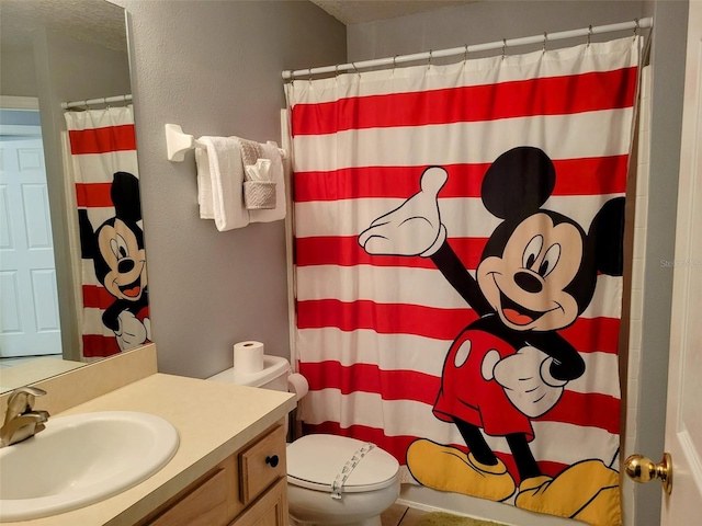 bathroom featuring toilet, vanity, and curtained shower