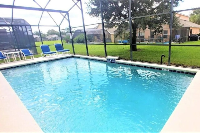 view of swimming pool featuring glass enclosure and a lawn