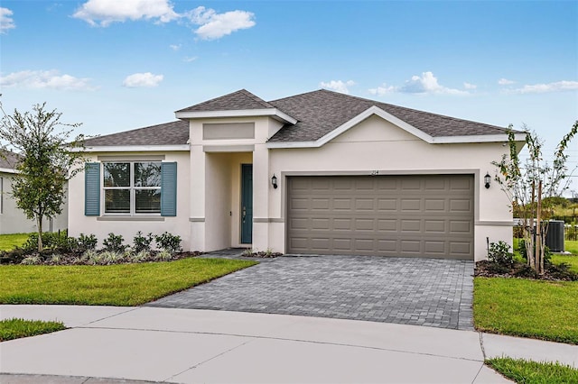 view of front facade featuring a front yard, central AC unit, stucco siding, decorative driveway, and an attached garage