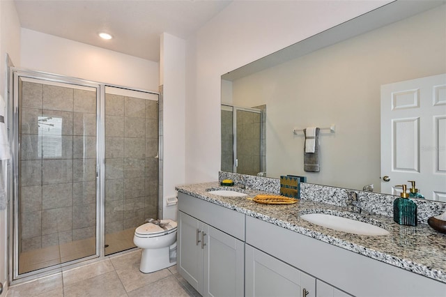 bathroom with a sink, toilet, a shower stall, and tile patterned floors