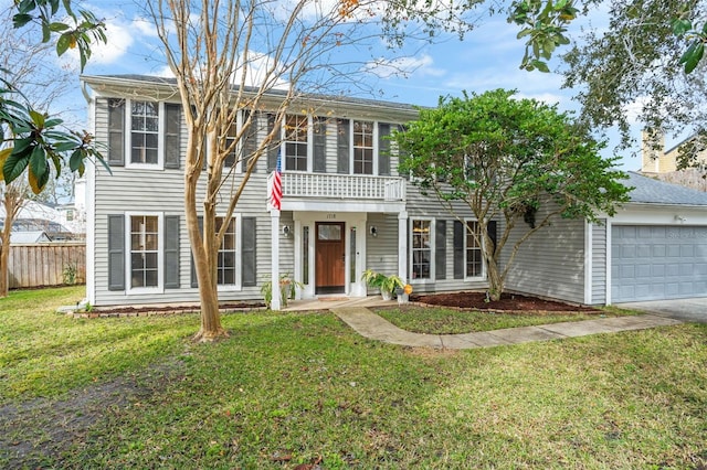 colonial-style house featuring a front lawn, a balcony, and a garage