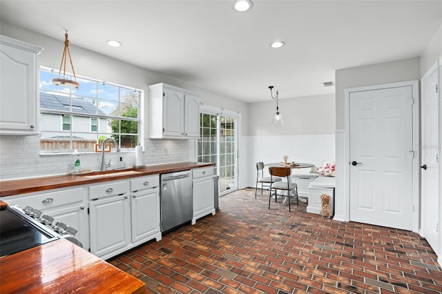 kitchen featuring white cabinetry, sink, pendant lighting, and stainless steel appliances