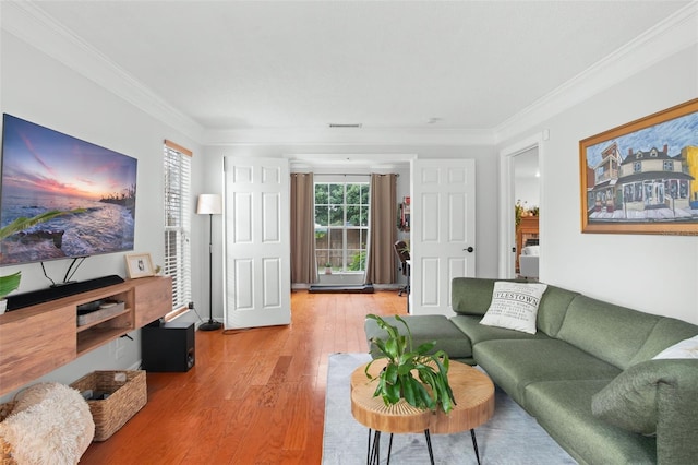 living room with hardwood / wood-style flooring and crown molding