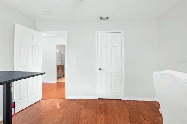 interior space featuring a textured ceiling and hardwood / wood-style flooring