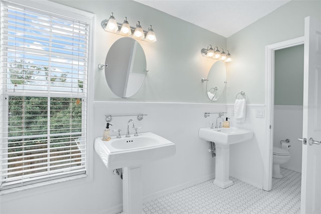 bathroom with toilet and double sink