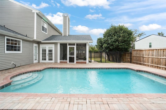 view of pool featuring a patio area, a sunroom, and french doors