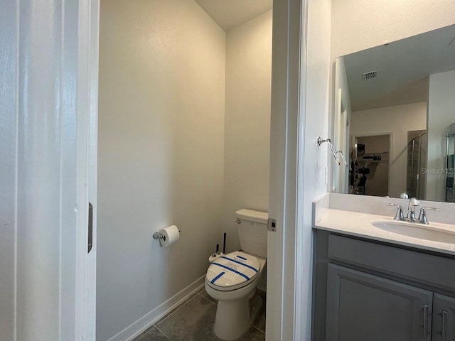 bathroom featuring toilet, tile patterned floors, and vanity