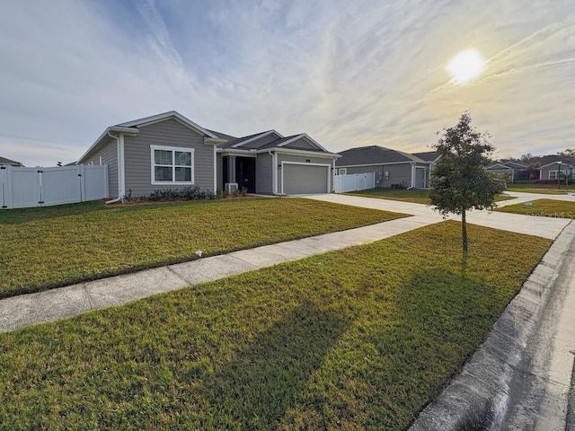 ranch-style home featuring a garage and a lawn