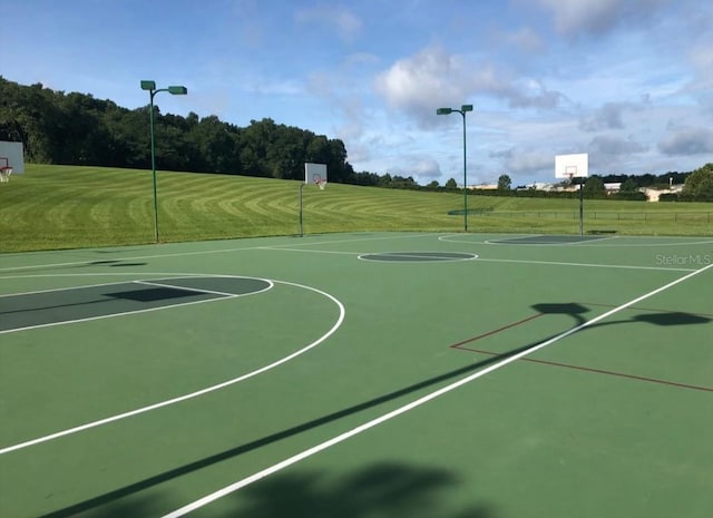 view of sport court with a lawn