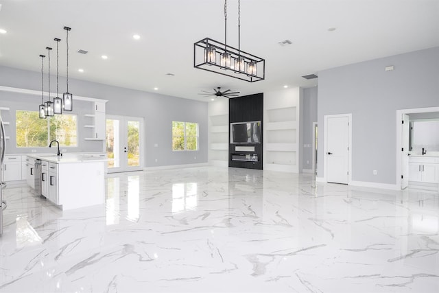 kitchen with a kitchen island, pendant lighting, sink, white cabinets, and ceiling fan