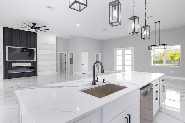 kitchen with sink, stainless steel dishwasher, an island with sink, light stone countertops, and white cabinets