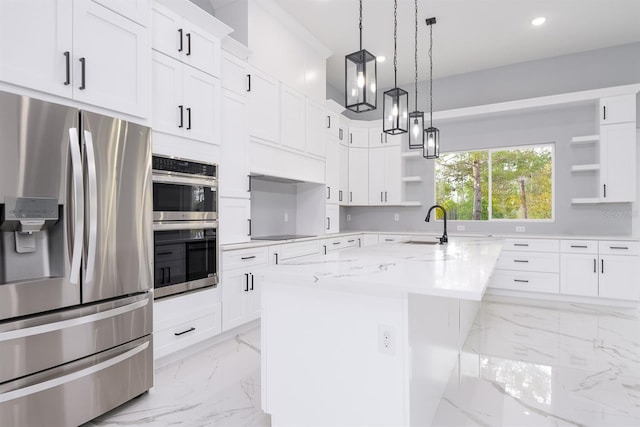 kitchen with white cabinetry, light stone counters, hanging light fixtures, a center island with sink, and appliances with stainless steel finishes