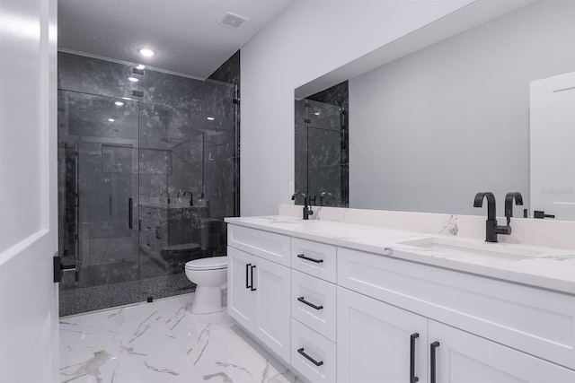 bathroom with vanity, toilet, a shower with door, and a textured ceiling