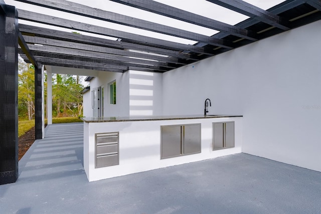 view of patio featuring an outdoor kitchen and sink