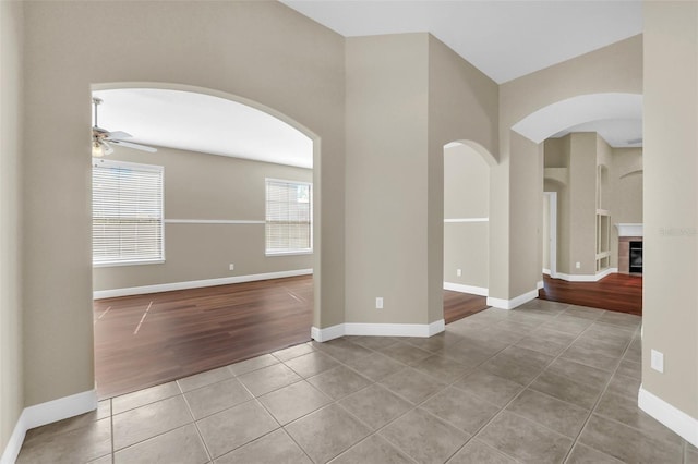 tiled spare room with ceiling fan