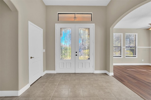 foyer with ceiling fan, light tile patterned floors, and french doors