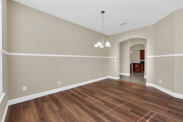 unfurnished dining area featuring dark wood-type flooring and a chandelier