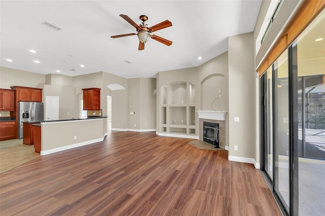 unfurnished living room featuring ceiling fan and dark hardwood / wood-style floors